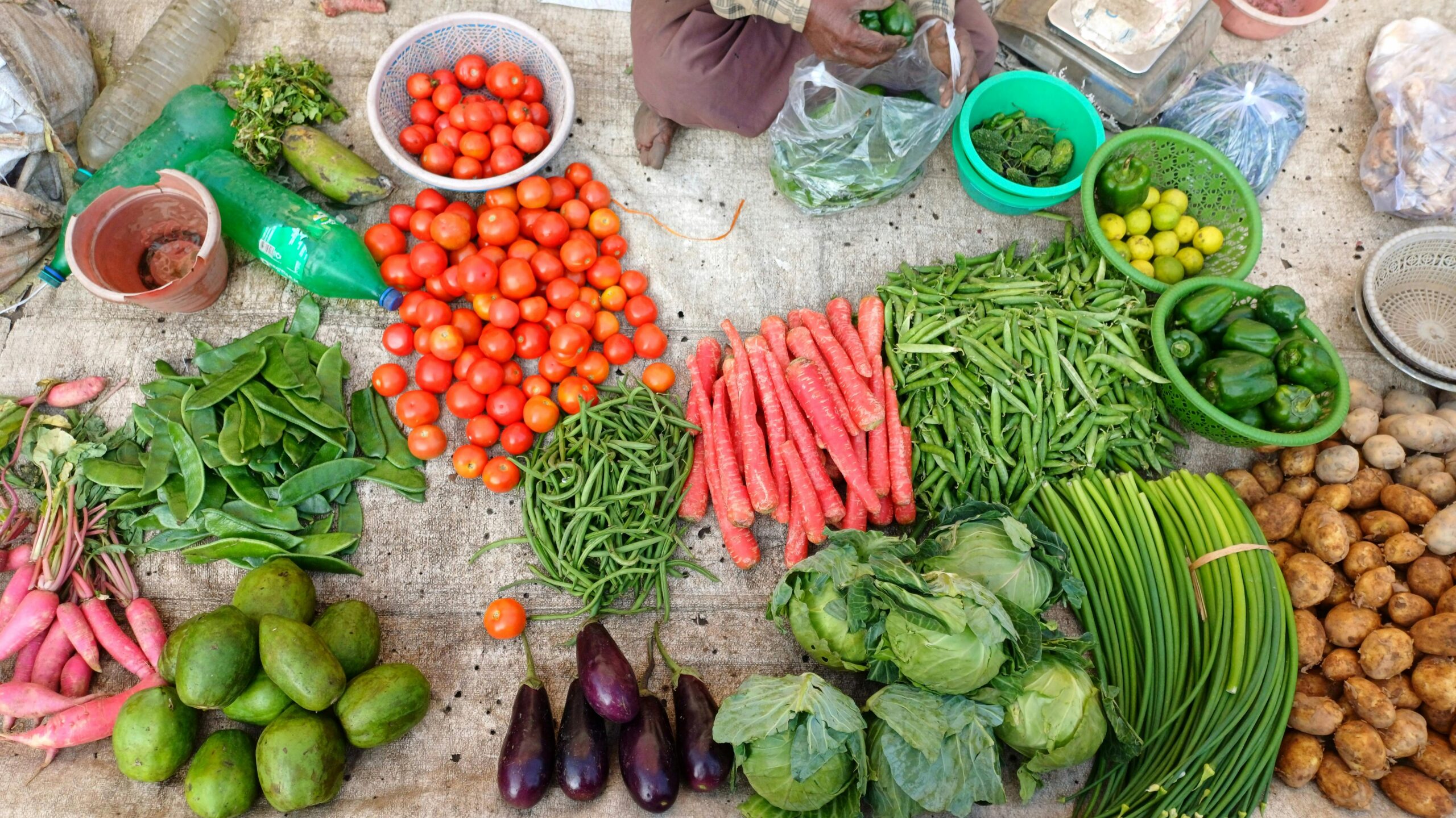 A vibrant display of fresh vegetables at an outdoor market stall.